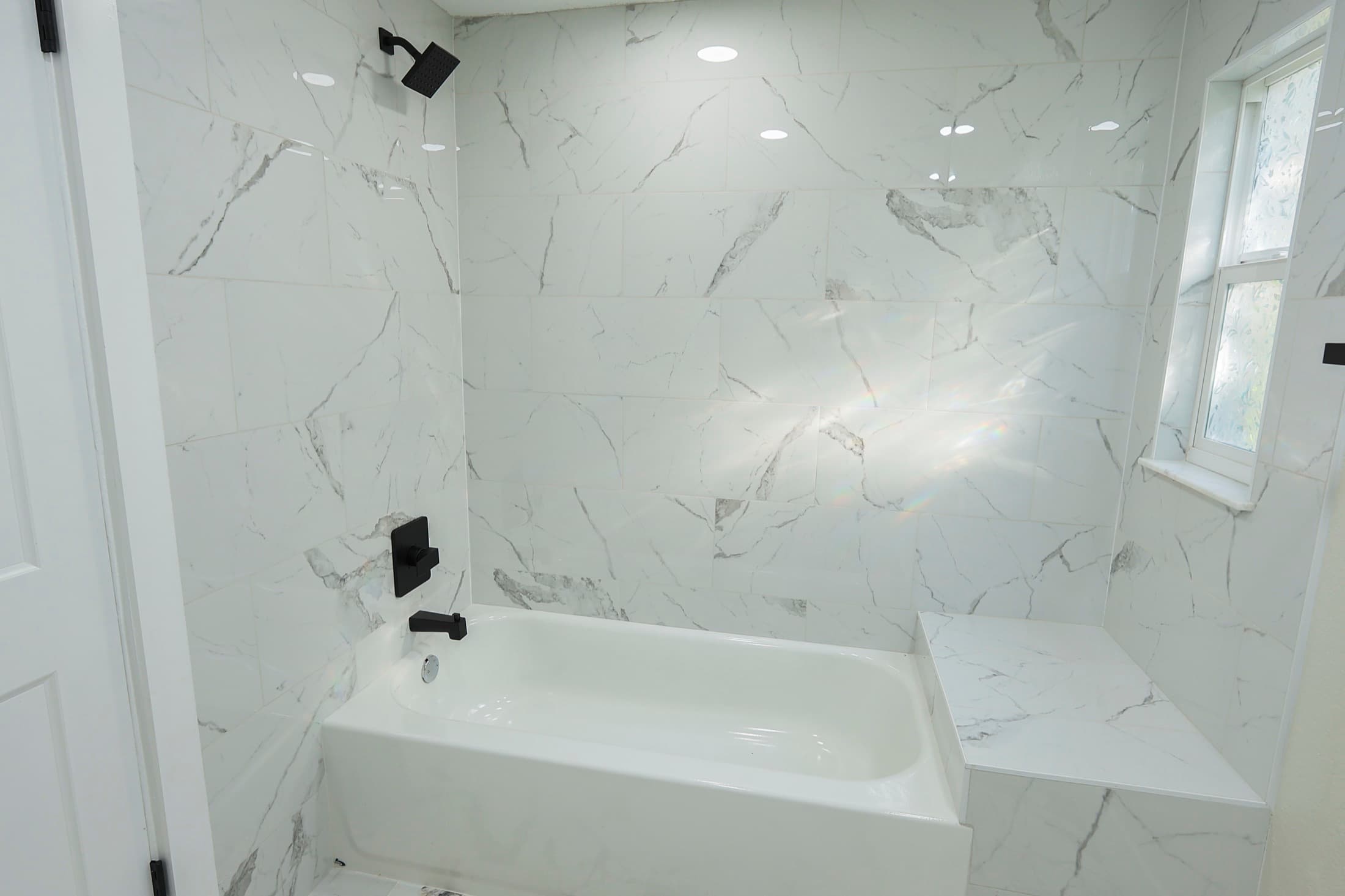 Marble shower and soaking tub with modern fixtures